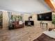 Bright living room with wood-style flooring, a modern TV, and wood burning stove at 28268 Shadow Mountain Dr, Conifer, CO 80433