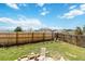 Spacious backyard with a mix of grass, brick patio, wooden fence, and mountain views at 7647 Elmwood St, Littleton, CO 80125