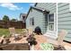 Backyard with stone patio, seating, grill, and access to the house with a green door at 7647 Elmwood St, Littleton, CO 80125