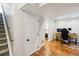 Finished basement area with wood floors, stairs, and a door to a possible storage area at 7647 Elmwood St, Littleton, CO 80125