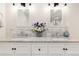 Bright bathroom features a double vanity with marble countertop and decorative floral accents at 7647 Elmwood St, Littleton, CO 80125