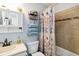Cozy bathroom offers storage shelves, decorative plants, and neutral colored shower and bathtub at 7647 Elmwood St, Littleton, CO 80125