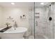 Luxurious bathroom featuring a free-standing tub and glass-enclosed shower with stylish finishes and built-in storage at 7647 Elmwood St, Littleton, CO 80125