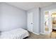 Cozy bedroom features neutral walls, white trim, and an attached bathroom providing a calm personal space at 7647 Elmwood St, Littleton, CO 80125