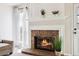 Close up of the cozy brick fireplace with white mantle and hearth at 7647 Elmwood St, Littleton, CO 80125