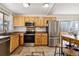 Bright kitchen with stainless steel appliances, wood cabinets, and tile flooring at 7647 Elmwood St, Littleton, CO 80125