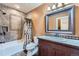 Bathroom with a shower-tub combo, dark wood vanity and a decorative mirror at 4725 Palmer Ridge Dr, Parker, CO 80134