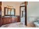 Bathroom featuring a dark wood vanity, granite counters, decorative mirror and tiled floors at 4725 Palmer Ridge Dr, Parker, CO 80134