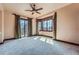 Spacious bedroom with a ceiling fan, neutral carpet, and three windows overlooking the backyard at 4725 Palmer Ridge Dr, Parker, CO 80134
