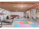 Unfinished basement with exposed beams, colorful mats, and ample space for customization at 525 Remington Dr, Hudson, CO 80642