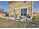 Backyard with a concrete patio, grill, grass and yellow siding on the home at 55410 E 27Th Pl, Strasburg, CO 80136