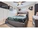 Bedroom features a modern platform bed with a dark green comforter and a ceiling fan at 55410 E 27Th Pl, Strasburg, CO 80136
