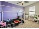 Bedroom features a modern bed frame, playful purple walls and neutral carpet at 55410 E 27Th Pl, Strasburg, CO 80136