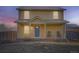 Charming two-story home with a welcoming front porch at dusk at 55410 E 27Th Pl, Strasburg, CO 80136