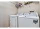 Bright laundry room with white washer and dryer and overhead wire shelving at 55410 E 27Th Pl, Strasburg, CO 80136