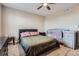Simple main bedroom with ceiling fan, black furnishings, and a gray crib at 55410 E 27Th Pl, Strasburg, CO 80136