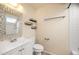 Bright bathroom featuring a framed mirror, shelves, and white fixtures, including toilet and vanity at 17093 E Tennessee Dr # 211, Aurora, CO 80017