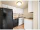 Well-lit kitchen featuring white cabinetry and black appliances at 17093 E Tennessee Dr # 211, Aurora, CO 80017
