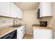 Functional kitchen featuring white cabinets, granite countertops, and stainless steel appliances at 17093 E Tennessee Dr # 211, Aurora, CO 80017