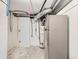 Unfinished basement space, including water heater and silver refrigerator at 235 S Stuart St, Denver, CO 80219