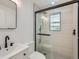 Modern bathroom featuring a glass-enclosed shower with mosaic tile floor and dark fixtures at 235 S Stuart St, Denver, CO 80219