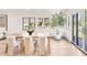 Bright dining area featuring a modern wood table and walls of bright windows at 4930 E Ellsworth Ave, Denver, CO 80246