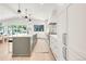 Spacious kitchen with bright white cabinetry, large island and access to dining area at 4930 E Ellsworth Ave, Denver, CO 80246