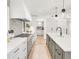 Contemporary kitchen with white cabinetry, stainless steel range hood, tiled backsplash, and center island at 4930 E Ellsworth Ave, Denver, CO 80246