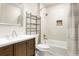 Bathroom with single sink vanity, tile backsplash, and shower over tub with decorative tile accent at 2254 S Eagle St, Aurora, CO 80014