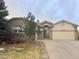 Charming single-Gathering home features a well-manicured lawn, brick facade, and attached two-car garage at 6686 Solana Dr, Castle Pines, CO 80108