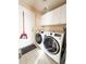 Bright laundry room with modern washer and dryer, white cabinets, and convenient access to the exterior at 6686 Solana Dr, Castle Pines, CO 80108