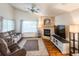 Inviting living room featuring a stone fireplace, ceiling fan and large windows with ample natural light at 6686 Solana Dr, Castle Pines, CO 80108