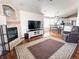 Inviting living room featuring a brick fireplace, modern furnishings, and seamless flow to dining and kitchen at 6686 Solana Dr, Castle Pines, CO 80108