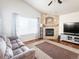 Cozy living room featuring a fireplace, modern furniture, large window, and vaulted ceiling at 6686 Solana Dr, Castle Pines, CO 80108