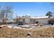 A backyard view with a patio, lovely landscaping, and mature trees in a winter wonderland at 13131 Mercury Dr, Lone Tree, CO 80124