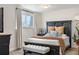 Comfortable bedroom featuring a decorative wood bed frame, a bench, and a large window for natural light at 13131 Mercury Dr, Lone Tree, CO 80124