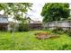 A well-maintained backyard features gardening boxes, green grass, and a mature tree at 11886 Birch Dr, Thornton, CO 80233