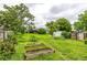 A sprawling backyard featuring raised garden beds, mature trees, and a glimpse of the house in the distance at 11886 Birch Dr, Thornton, CO 80233
