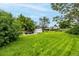 Wide shot of the backyard with abundant green space, mature trees, and a shed, perfect for outdoor activities at 11886 Birch Dr, Thornton, CO 80233