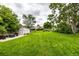 Lush backyard featuring a large lawn, mature trees, and storage shed at 11886 Birch Dr, Thornton, CO 80233
