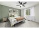 Comfortable bedroom featuring a ceiling fan, large window with curtains and an accent wall with art at 11886 Birch Dr, Thornton, CO 80233