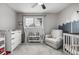 Well-lit Bedroom showcases a playful mural, modern crib, and comfortable chair at 11886 Birch Dr, Thornton, CO 80233