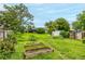 Picturesque backyard with raised garden beds, a green lawn, and mature trees enhancing the serene setting at 11886 Birch Dr, Thornton, CO 80233