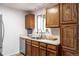 Practical kitchen with stainless steel appliances, oak cabinets, sink, and a view through the window at 11886 Birch Dr, Thornton, CO 80233