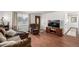 Cozy living room features hardwood floors, comfortable seating, and a large window for natural light at 11886 Birch Dr, Thornton, CO 80233