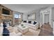 Bright, staged living room with hardwood floors, stone fireplace, and sliding glass doors to balcony at 4460 S Pitkin St # 120, Aurora, CO 80015