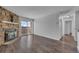 Bright living room with hardwood floors, stone fireplace, and sliding glass doors to balcony at 4460 S Pitkin St # 120, Aurora, CO 80015