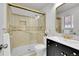 Bathroom featuring black and gold hardware, a glass shower, and tan tile at 11157 W Marlowe Ave, Jefferson, CO 80127