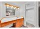 Bathroom with a long vanity, large mirror with lighting, and tiled shower at 11157 W Marlowe Ave, Jefferson, CO 80127