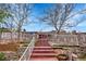 Charming home featuring a red staircase, a decorative fence and stone walls, providing a unique and inviting entrance at 11157 W Marlowe Ave, Jefferson, CO 80127